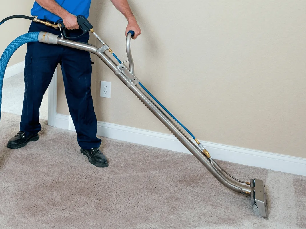 Professional operating a liquid removal machine on a carpeted floor in West Palm Beach, FL