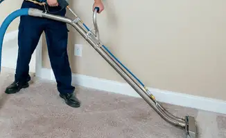Professional operating a liquid removal machine on a carpeted floor in West Palm Beach, FL